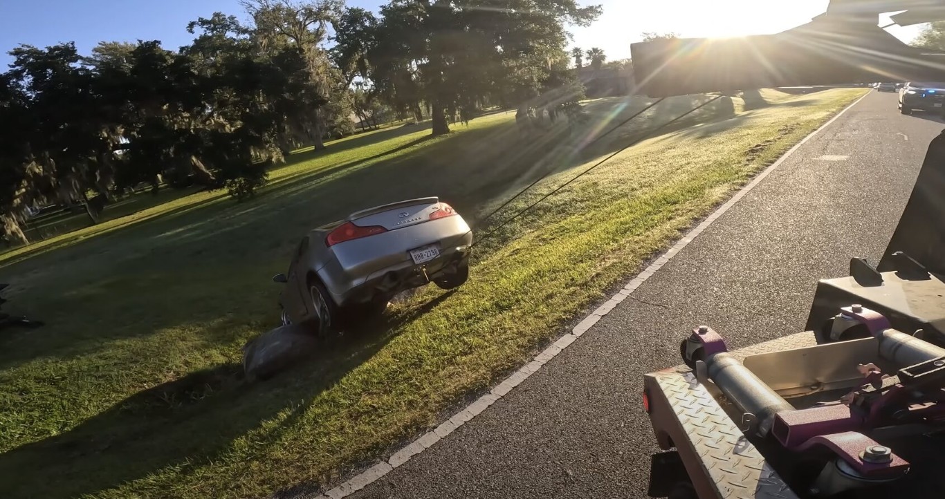 Silver Infiniti coupe being recovered from a roadside ditch after an accident in Islip, NY